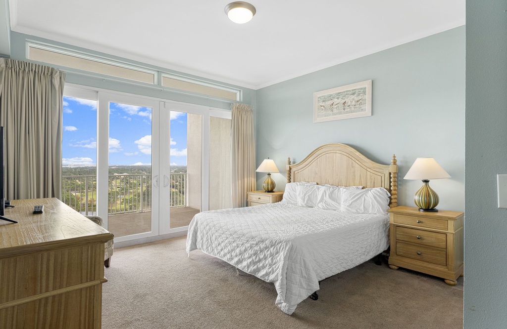 Relax in this coastal-style bedroom with balcony access and natural light.