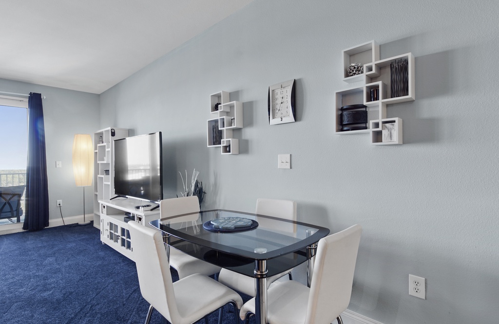 Modern dining area with glass table and wall-mounted shelves