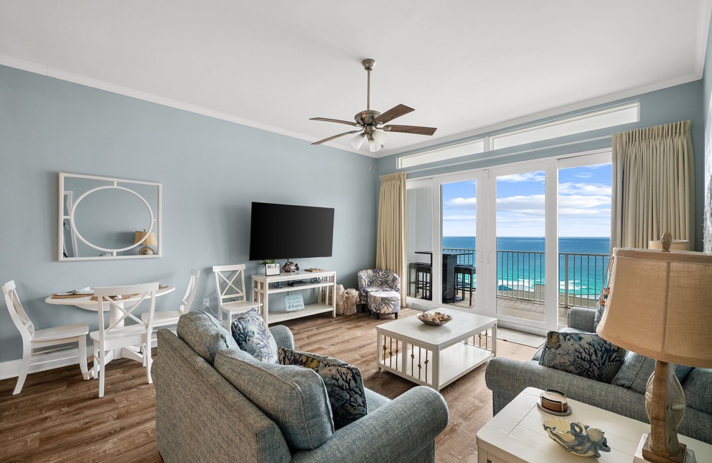 Relax in your beautifully appointed coastal living room, where soothing blues meet stunning ocean views through expansive windows.