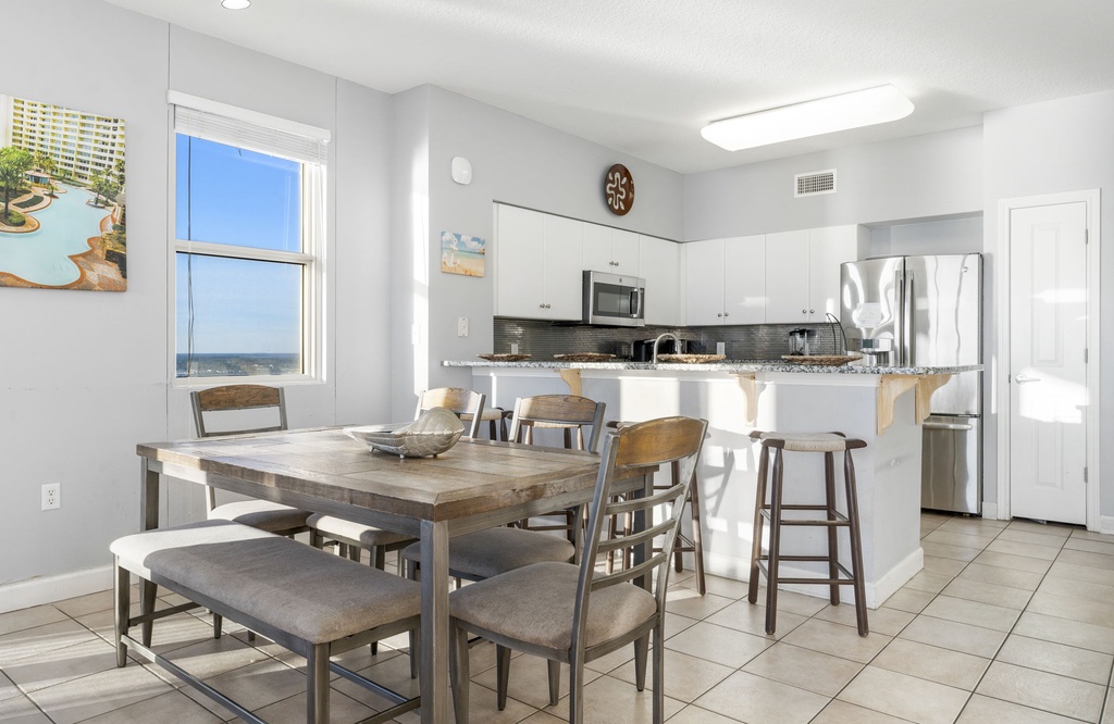 Modern kitchen and dining area with ocean views through the window.