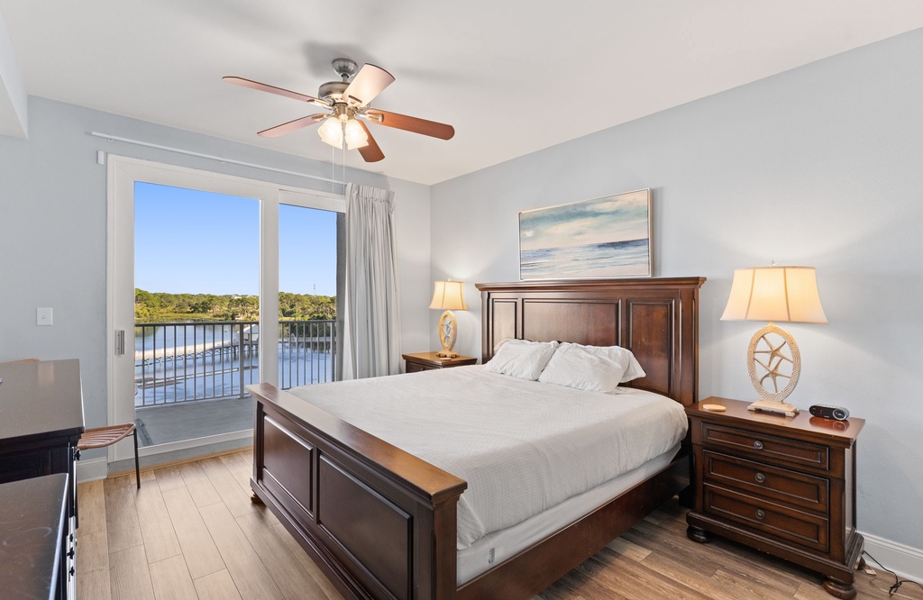 Relax in this serene bedroom with a water view and classic wooden furnishings.