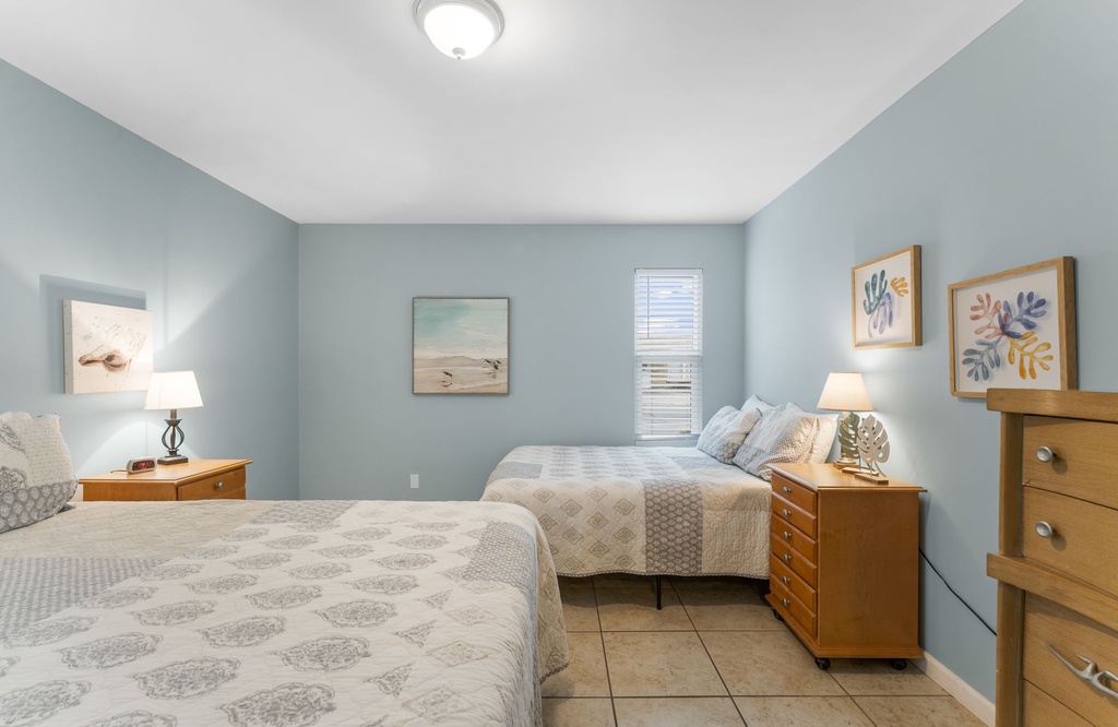 Spacious bedroom with two plush beds and soft blue walls for a relaxing stay