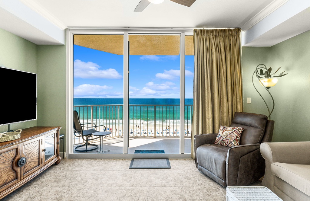 Relax in this comfortable living room with direct ocean views through sliding glass doors.