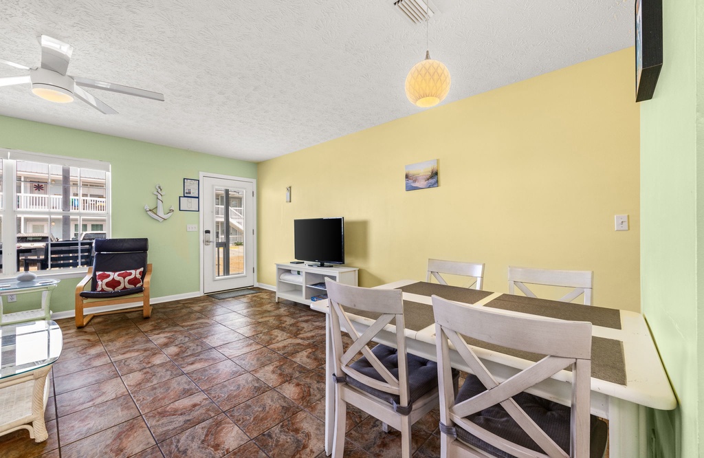 Settle into your bright, cheerful living space where soft coastal colors and an open floor plan create the perfect atmosphere for togetherness. Gather around the dining table for meals or unwind in front of the TV after a day of beach adventures.