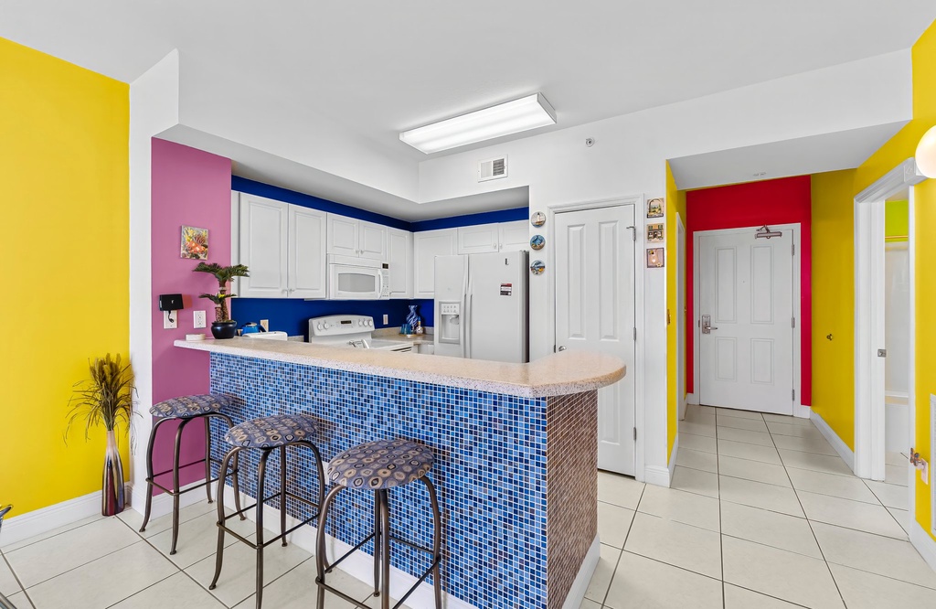 Colorful kitchen with a tiled breakfast bar and modern appliances