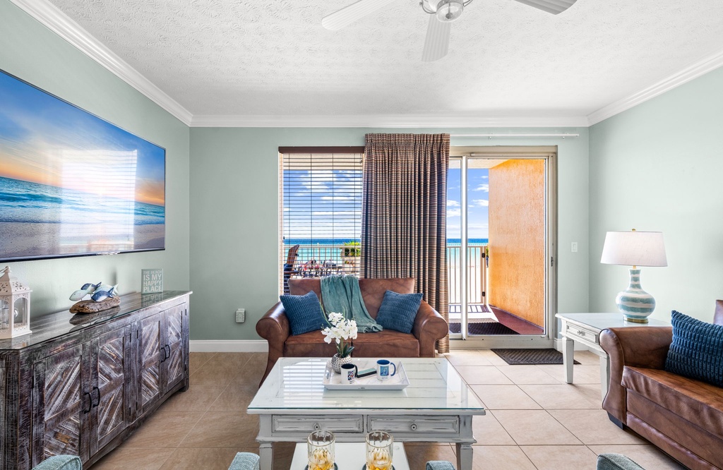 Relax in this coastal living room with ocean views and access to a private balcony.