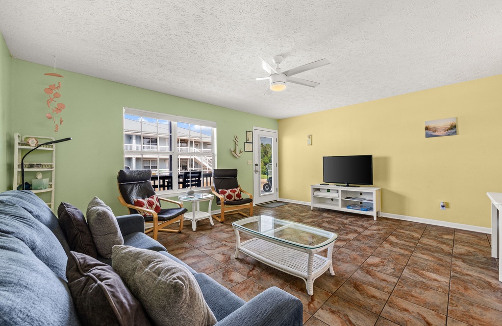 Bright and breezy living space where you can unwind on plush seating, catch your favorite shows, and enjoy the tropical color palette that brings vacation vibes indoors.