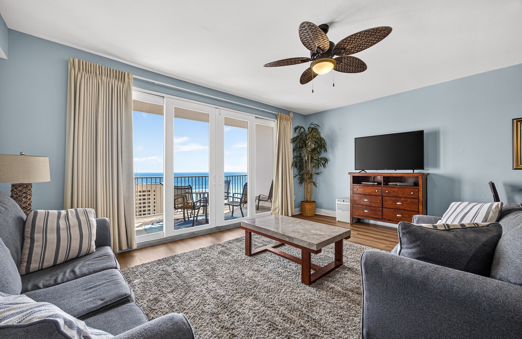 Unwind in your serene living space with plush seating, coastal breezes, and stunning sea views through private balcony doors—your perfect retreat awaits.