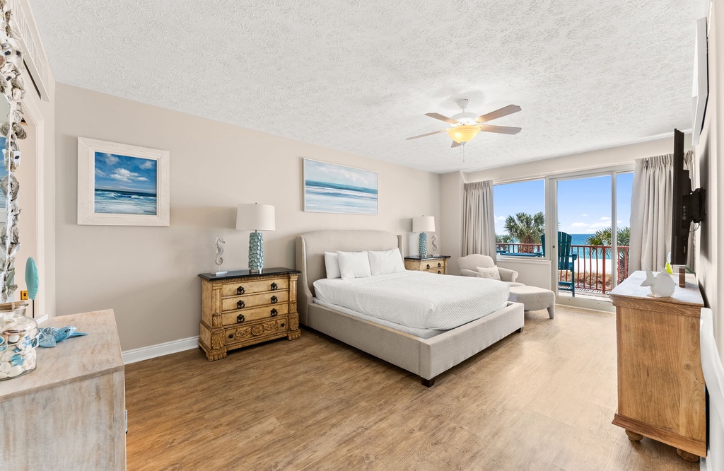 Spacious bedroom with ocean views and access to a balcony.