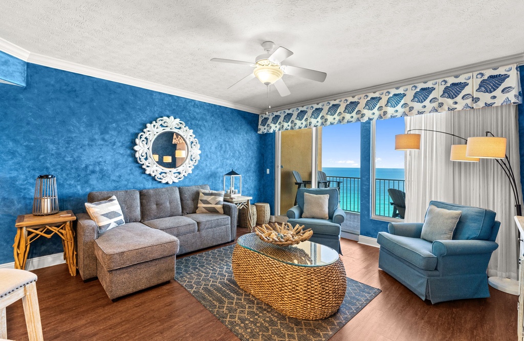 Relax in your coastal-themed living room with stunning ocean views through floor-to-ceiling windows, complete with comfortable seating and beach-inspired décor.