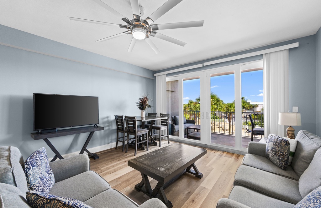 Settle into this bright, airy living space where coastal breezes flow through your private balcony doors. Gather around for dinner or unwind on plush sofas after a day exploring nearby beaches.