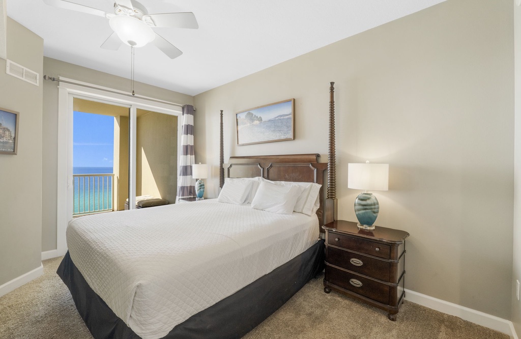 Relax in this bright bedroom with ocean views and classic wooden furniture.