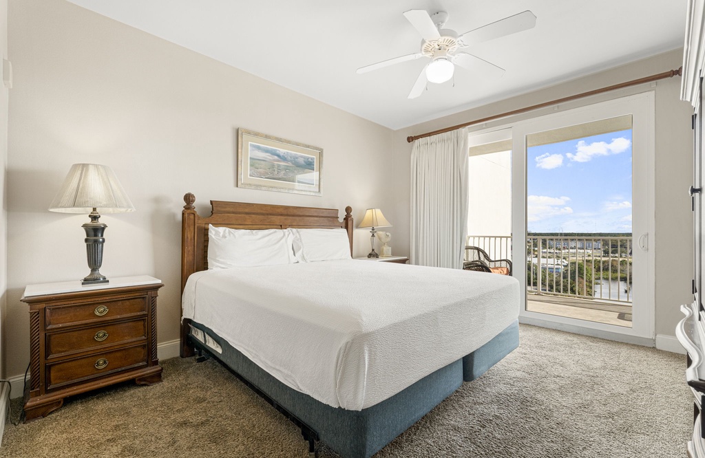 Bedroom with a wooden bed frame and balcony access overlooking the outdoors