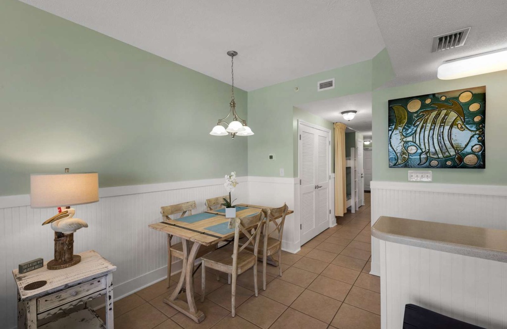 Cozy dining area with rustic wooden chairs and soft green walls for a relaxing meal.