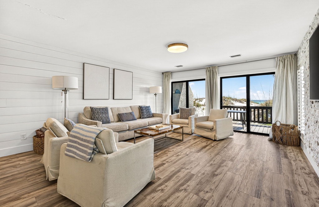 Sink into coastal comfort in this bright living space, where soft furnishings and beachside views through the glass doors invite you to unwind and breathe in the ocean air.