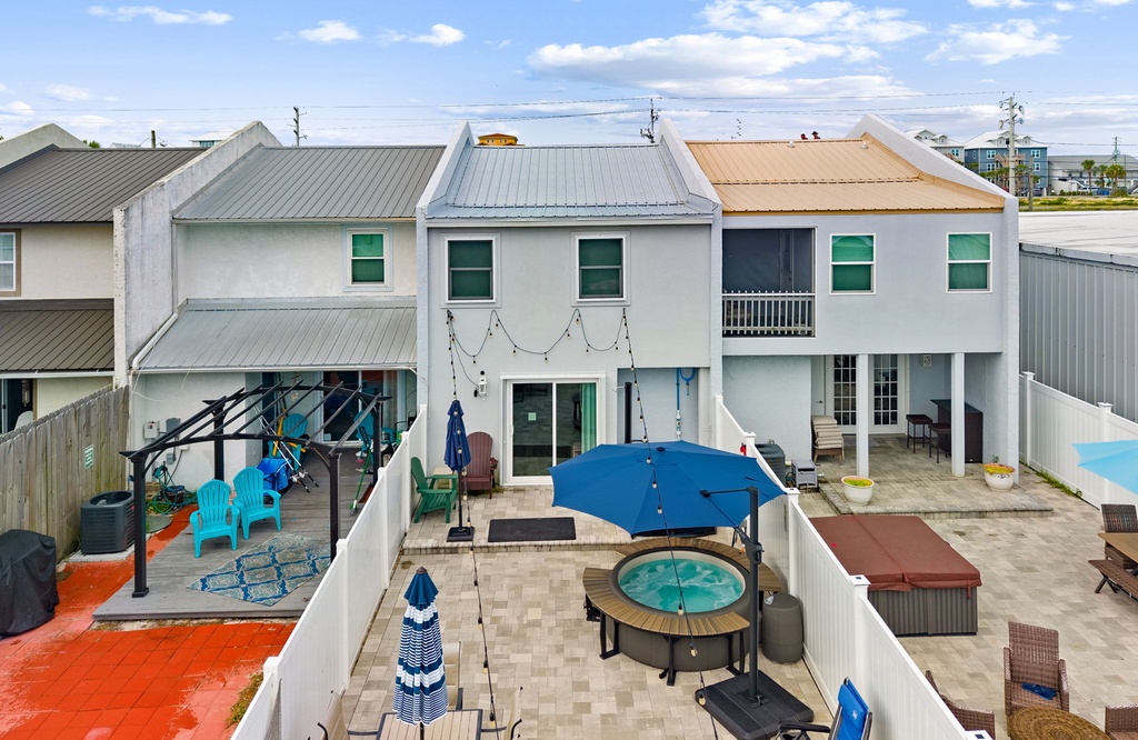 Multi-unit vacation property with expansive outdoor courtyard featuring a shared hot tub, lounge seating, and covered patio areas—perfect for groups seeking relaxation and togetherness.