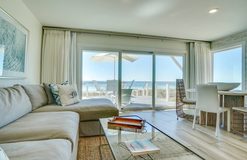 Unwind in your coastal living room where plush seating and sliding glass doors frame breathtaking ocean views, inviting you to relax in breezy, sun-filled comfort.