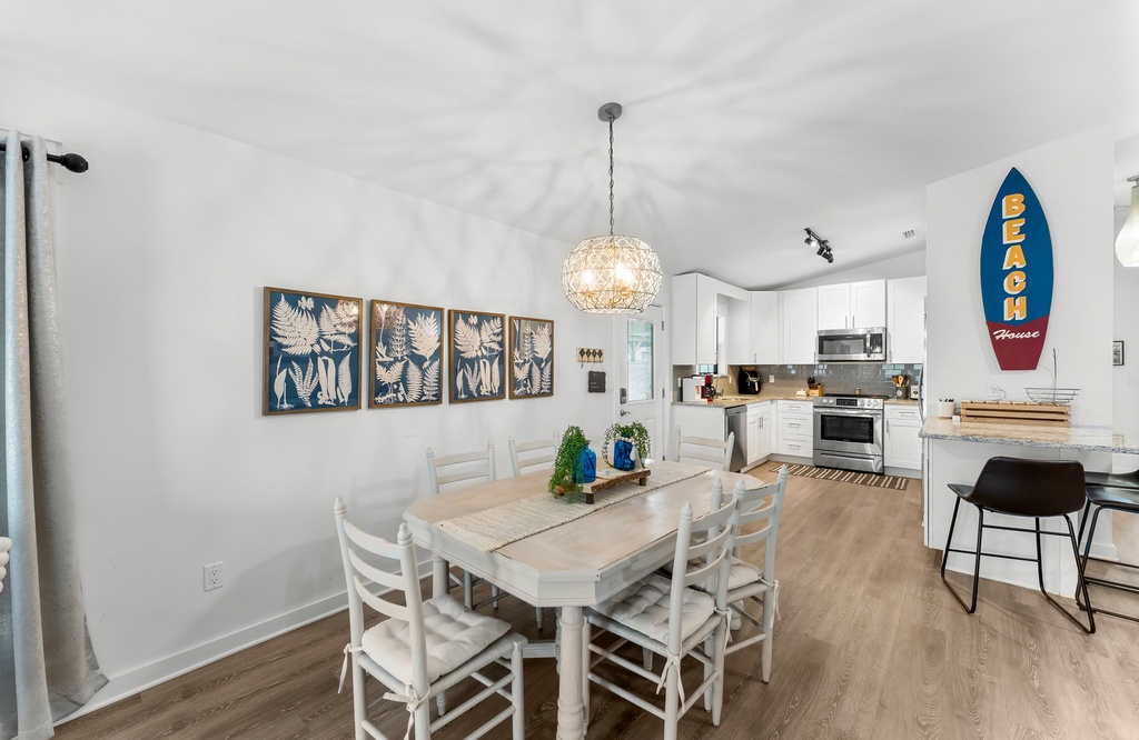 Dining area with coastal decor adjacent to a modern kitchen