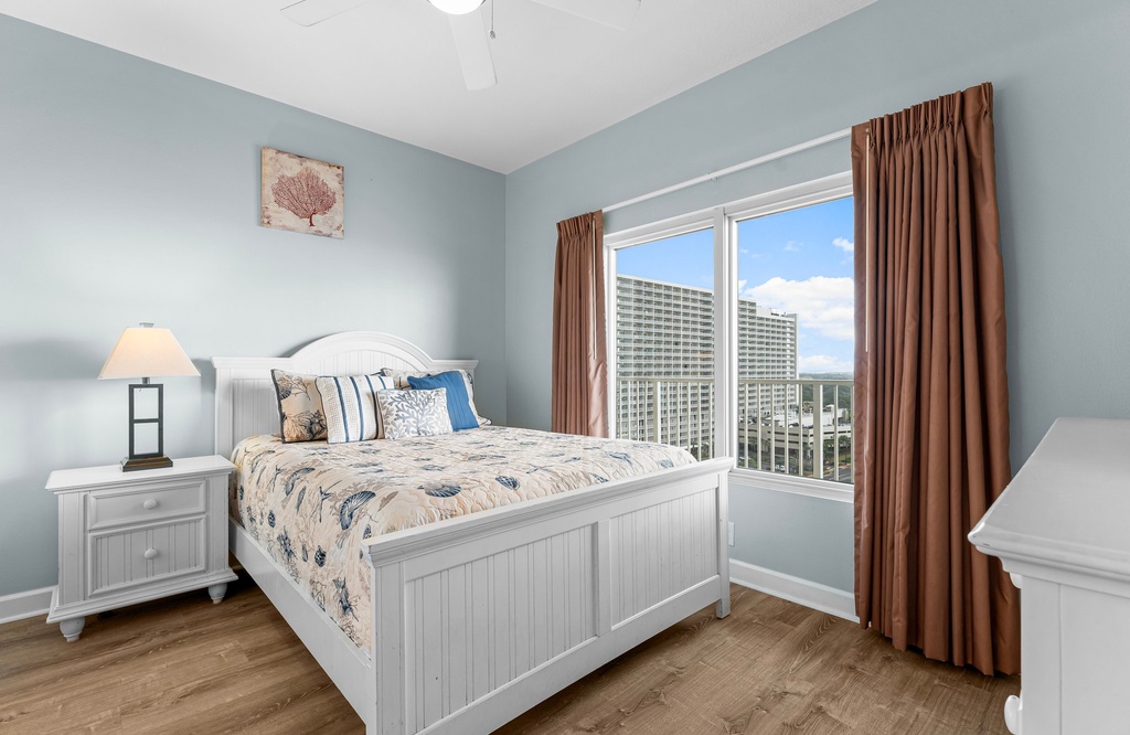 Cozy bedroom with a white wooden bed and city views through the window