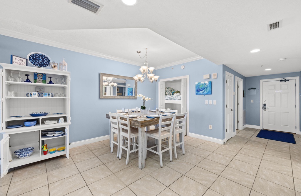 dining area with a rustic wooden table and white chairs set against soft blue walls