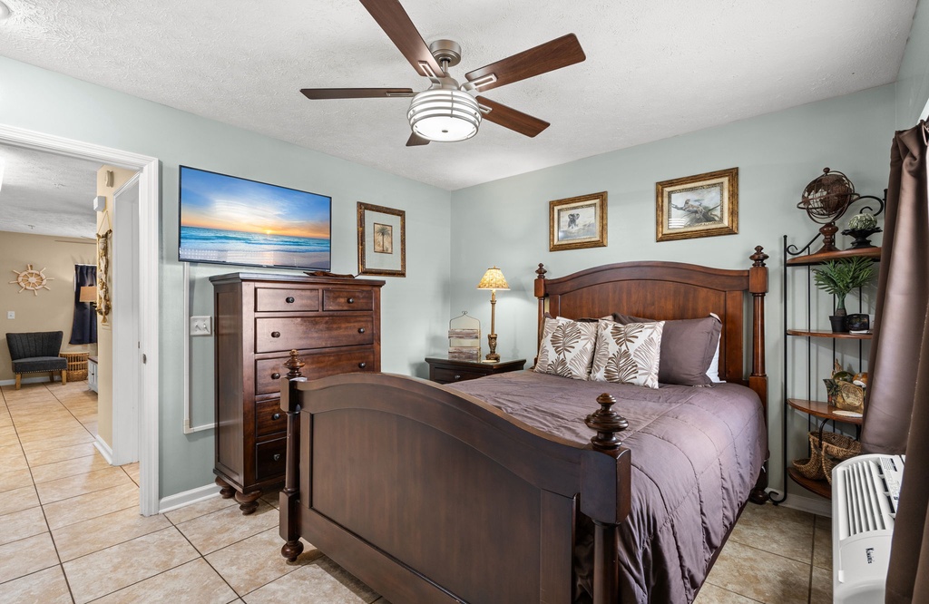 Cozy bedroom with classic wooden furniture and a ceiling fan.