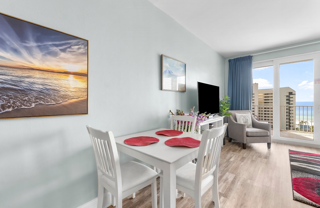 dining area with ocean view artwork and city skyline through large windows