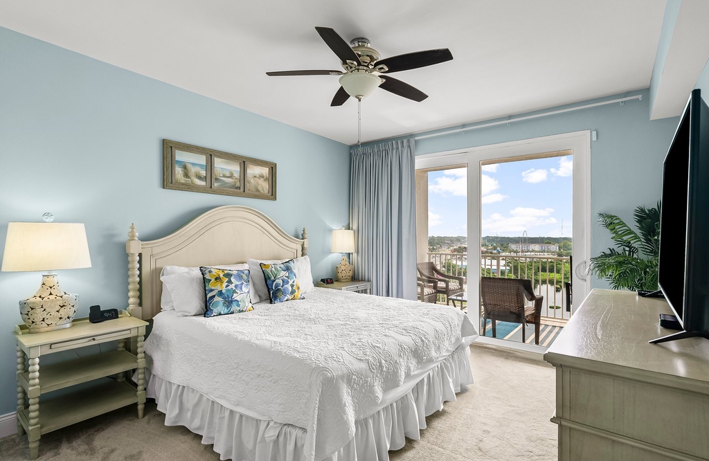 Relax in this bright bedroom with balcony access and scenic views.