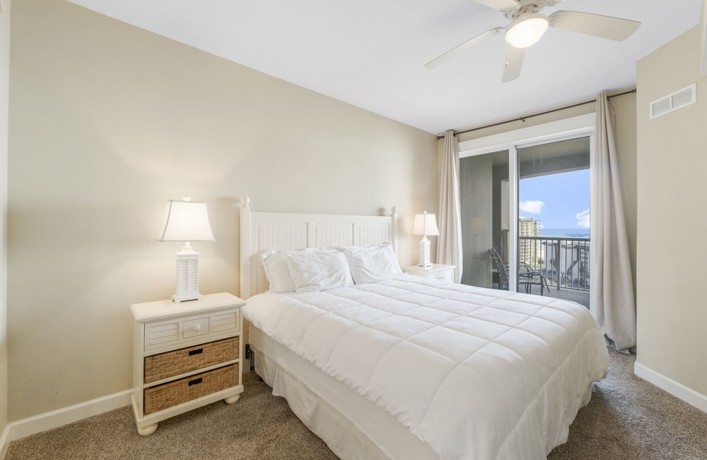 Bright bedroom with balcony access and coastal views