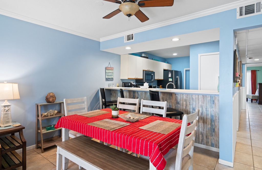 Dining area with a red-striped tablecloth and open kitchen in a cozy setting