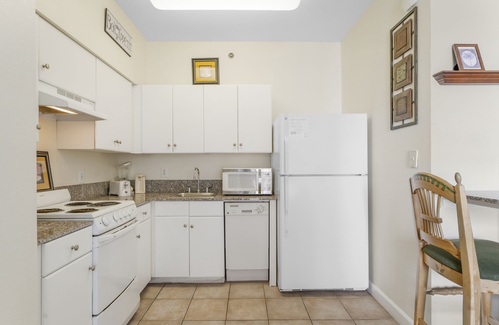 Compact kitchenette w/ white cabinetry & full-size fridge — everything you need to keep it simple.