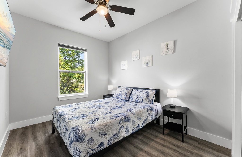 Bright bedroom with a cozy bed, ceiling fan, and natural light from the window