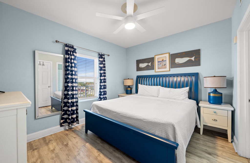 Relax in this coastal-inspired bedroom with a king-size bed and natural light.