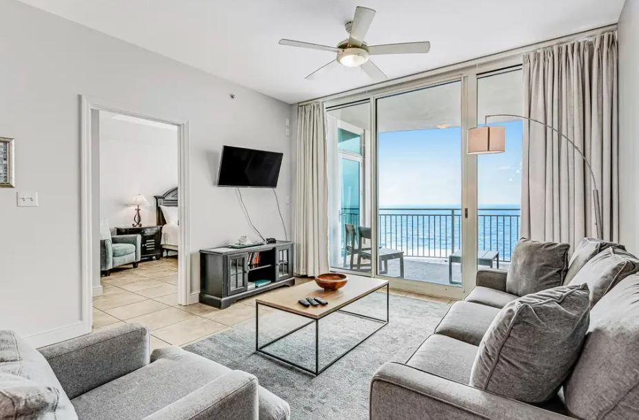 Imagine unwinding in this bright living room where ocean breezes and endless blue horizons greet you through your private balcony doors. Plush seating and calming coastal views create the perfect retreat.