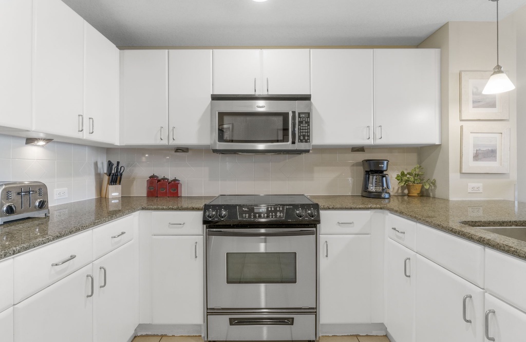Modern kitchen with stainless steel appliances and ample white cabinetry