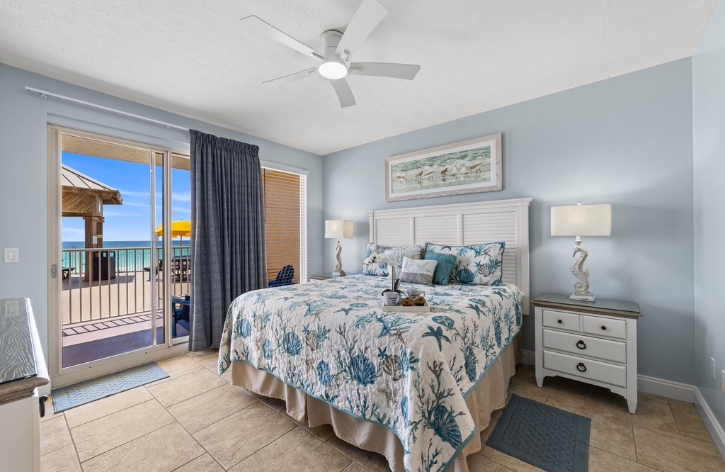 Relax in this coastal-themed bedroom with direct balcony access and ocean views.