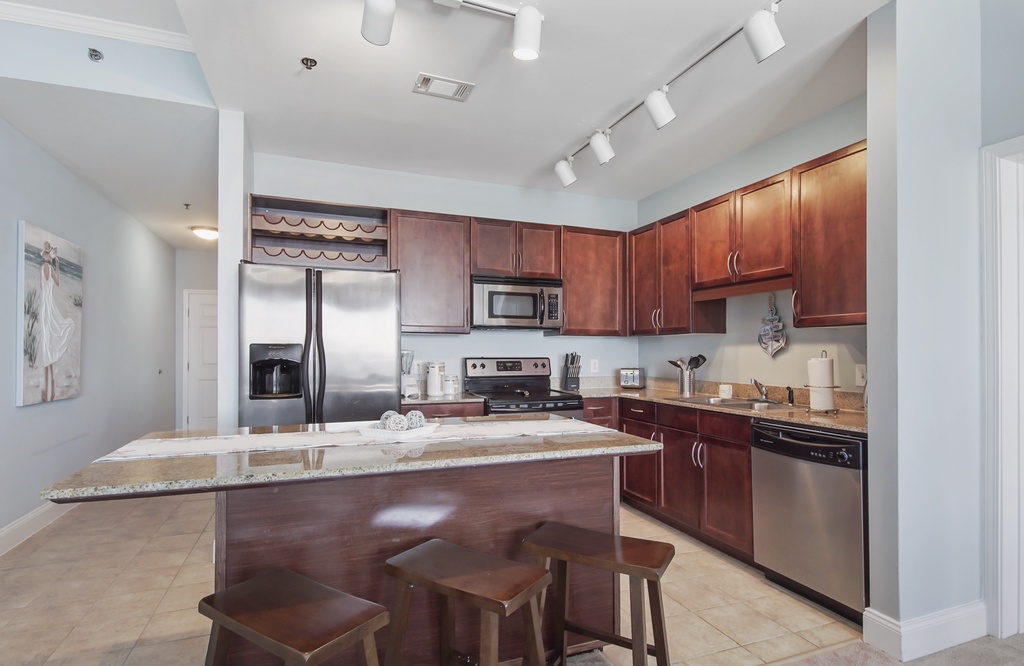 Modern kitchen with stainless steel appliances and a granite island for casual dining.