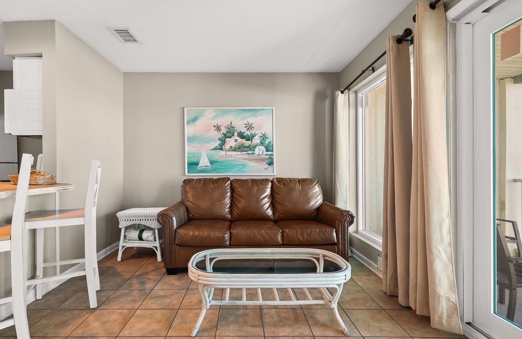 Sink into this cozy leather sofa and unwind with tropical artwork setting the perfect vacation mood in your comfortable living space.