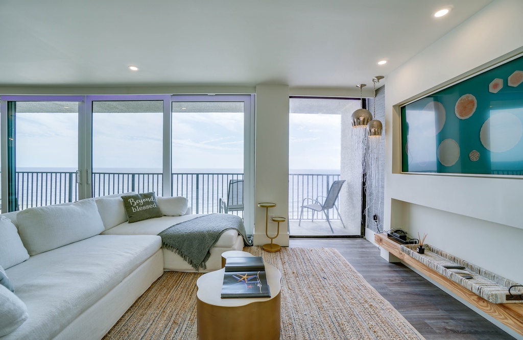 Sink into plush sofas and let ocean breezes refresh your spirit. This bright living room pairs coastal style with comfort, offering panoramic sea views and a serene escape from everyday life.