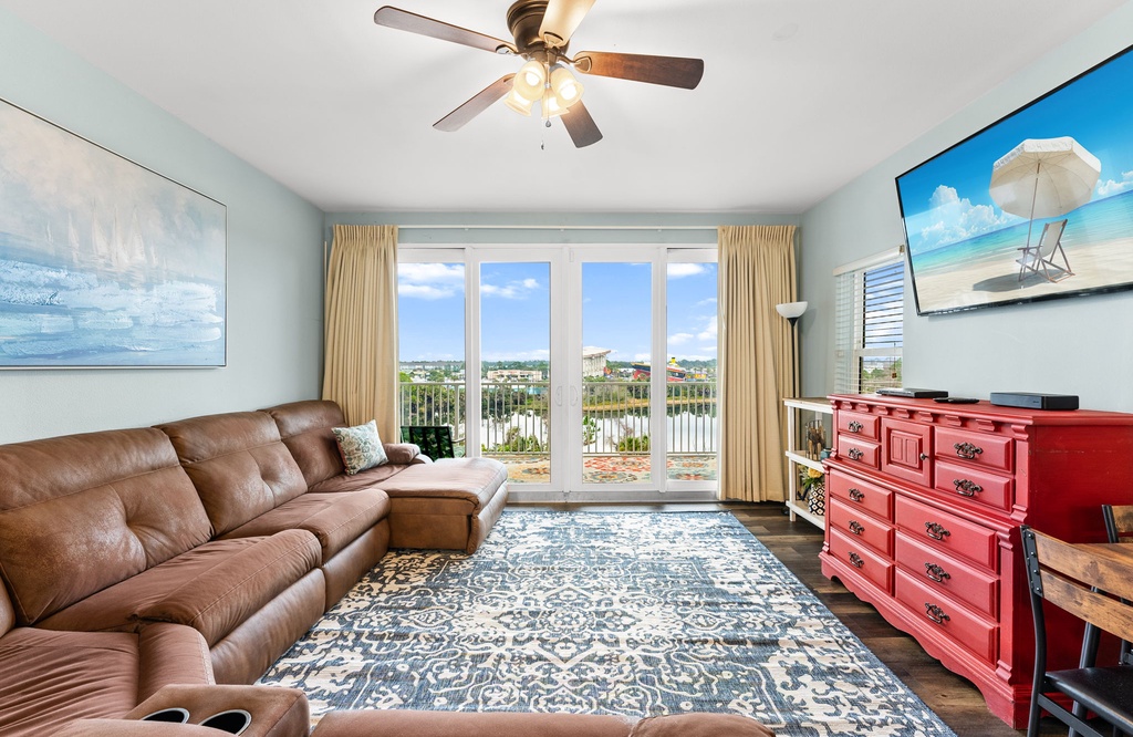 Unwind in your coastal-inspired living room with plush sectional seating, stunning lake views from your private balcony, and cheerful beach artwork.