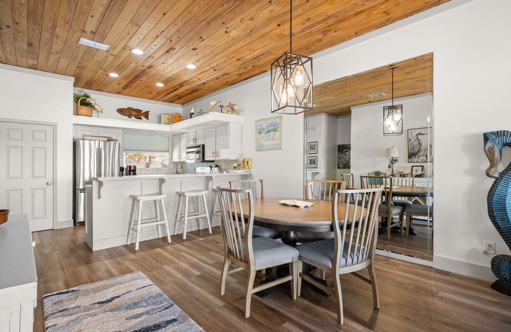 Modern kitchen and dining area with wood ceiling and stainless steel appliances