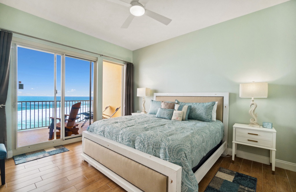 Airy primary bedroom w/ a plush bed, ceiling fan & gorgeous ocean views right from the pillow.