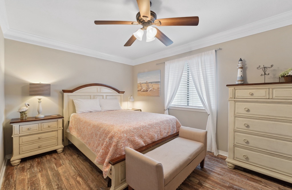 Cozy bedroom with a ceiling fan and soft natural light from the window.