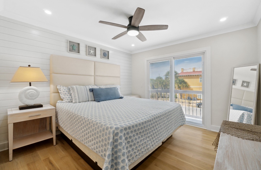 bright bedroom with a bed and balcony access