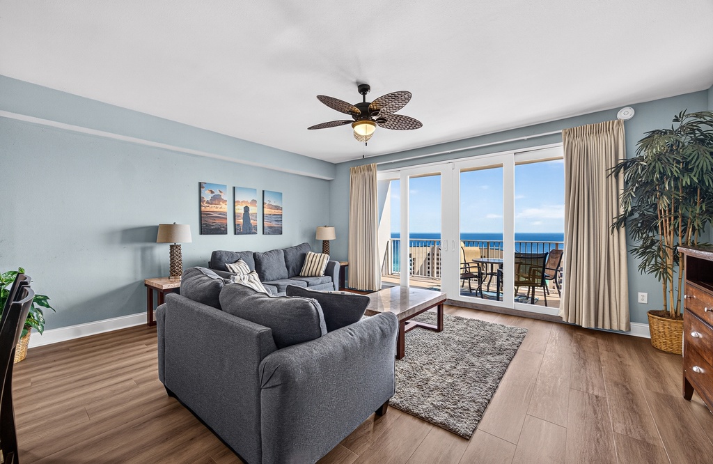 Relax in your bright, coastal-styled living space with plush seating and stunning ocean views through your private balcony doors. Unwind beneath the tropical ceiling fan as you soak in the endless blue horizon.