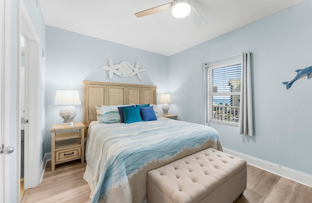 Cozy bedroom with ocean-inspired decor and a view through the window.