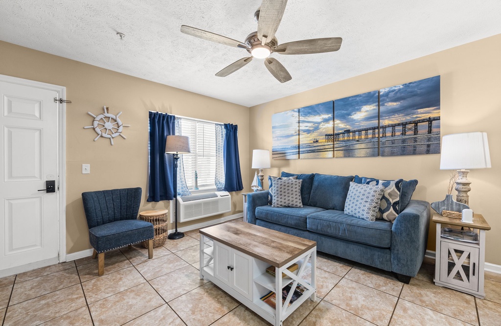 Relax in your coastal-themed living room with plush seating, nautical accents, and ocean artwork creating the perfect beachside retreat atmosphere.