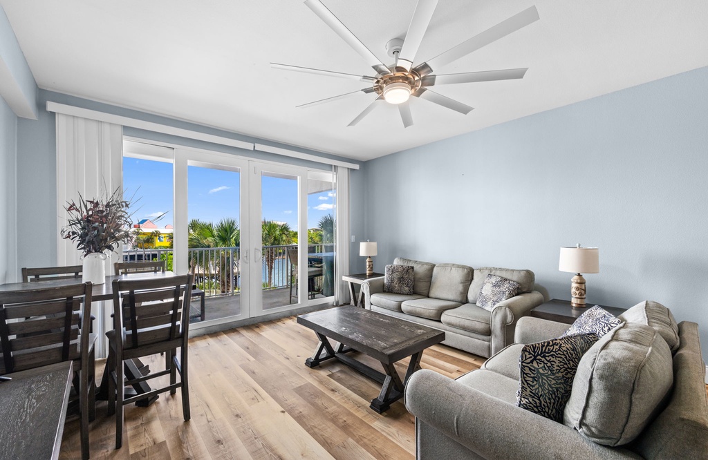 Settle into this airy living space where soft blue walls and comfortable seating invite you to unwind. Step through the glass doors to your private balcony and soak in warm coastal breezes.