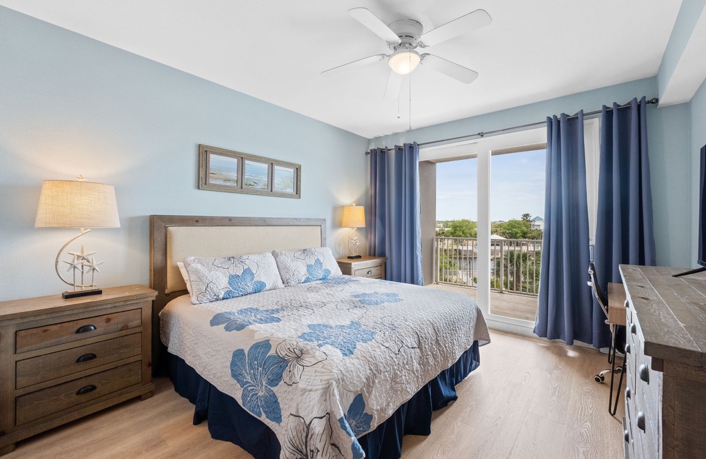 Relax in this bright bedroom with coastal decor and balcony access.