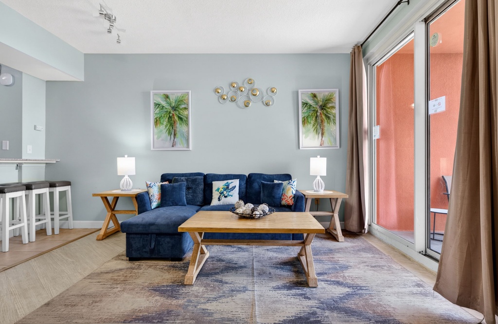 Sink into your plush navy sofa and soak up natural light from your private balcony in this coastal-inspired retreat.