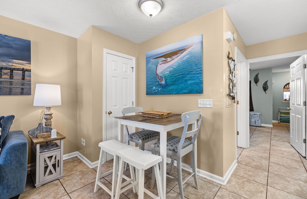 Cozy dining area with coastal artwork and natural lighting.